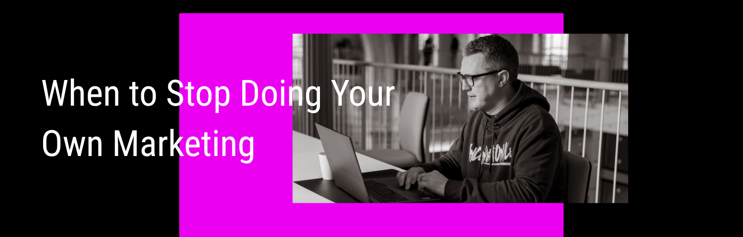 Blog Banner of the blog "When to Stop Doing Your Own Marketing". There's a photo of Andy at work on a laptop overlaid on a pink square on a black background.